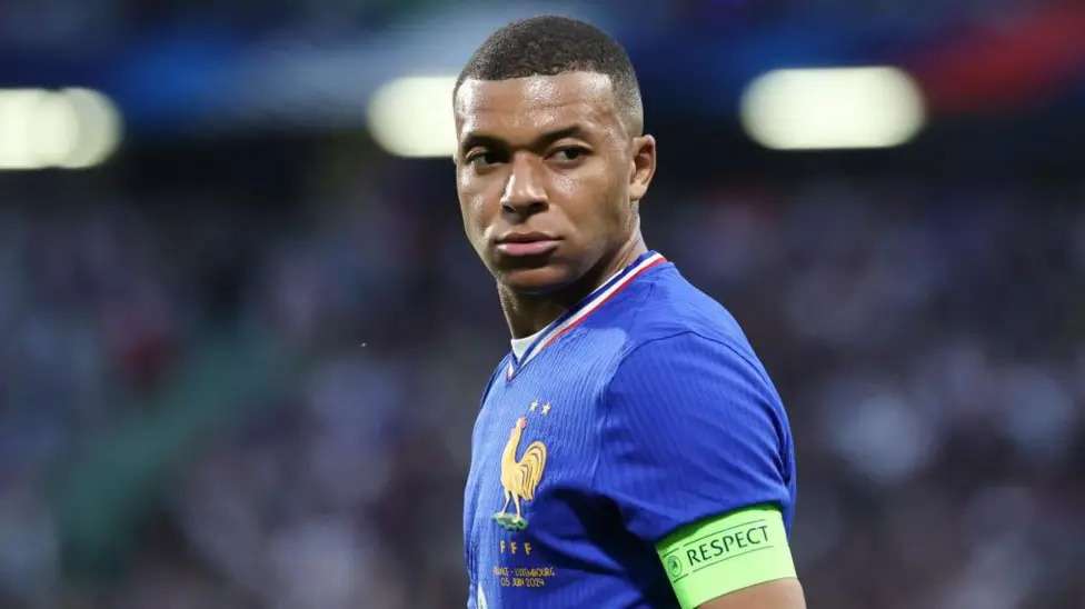 MbappeKylian Mbappé wearing France’s blue kit and a green captain’s armband.